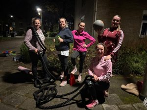 Nelleke (knielend rechtsonderin) geeft een bootcamp les voor haar buren